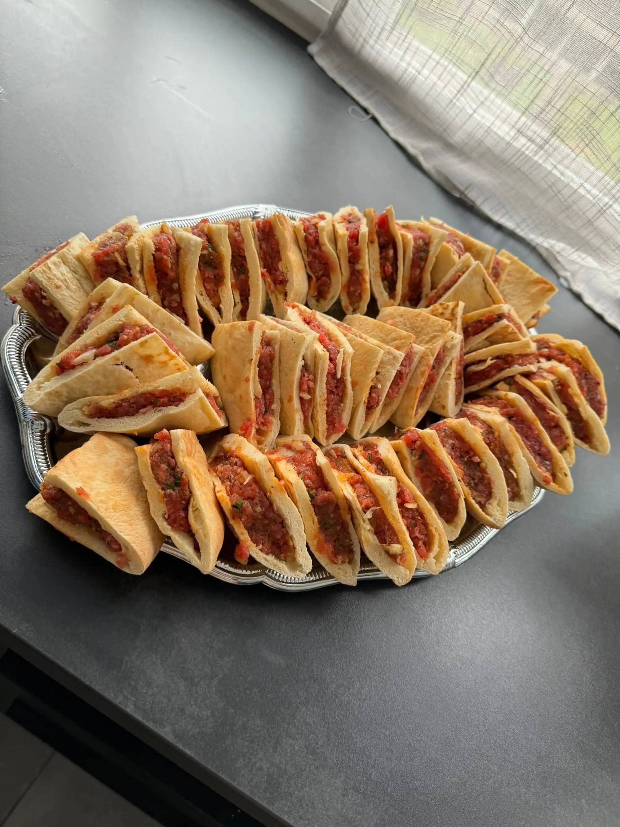 Arayes, pains farcis à la viande grillés, dressés en couronne sur un plateau