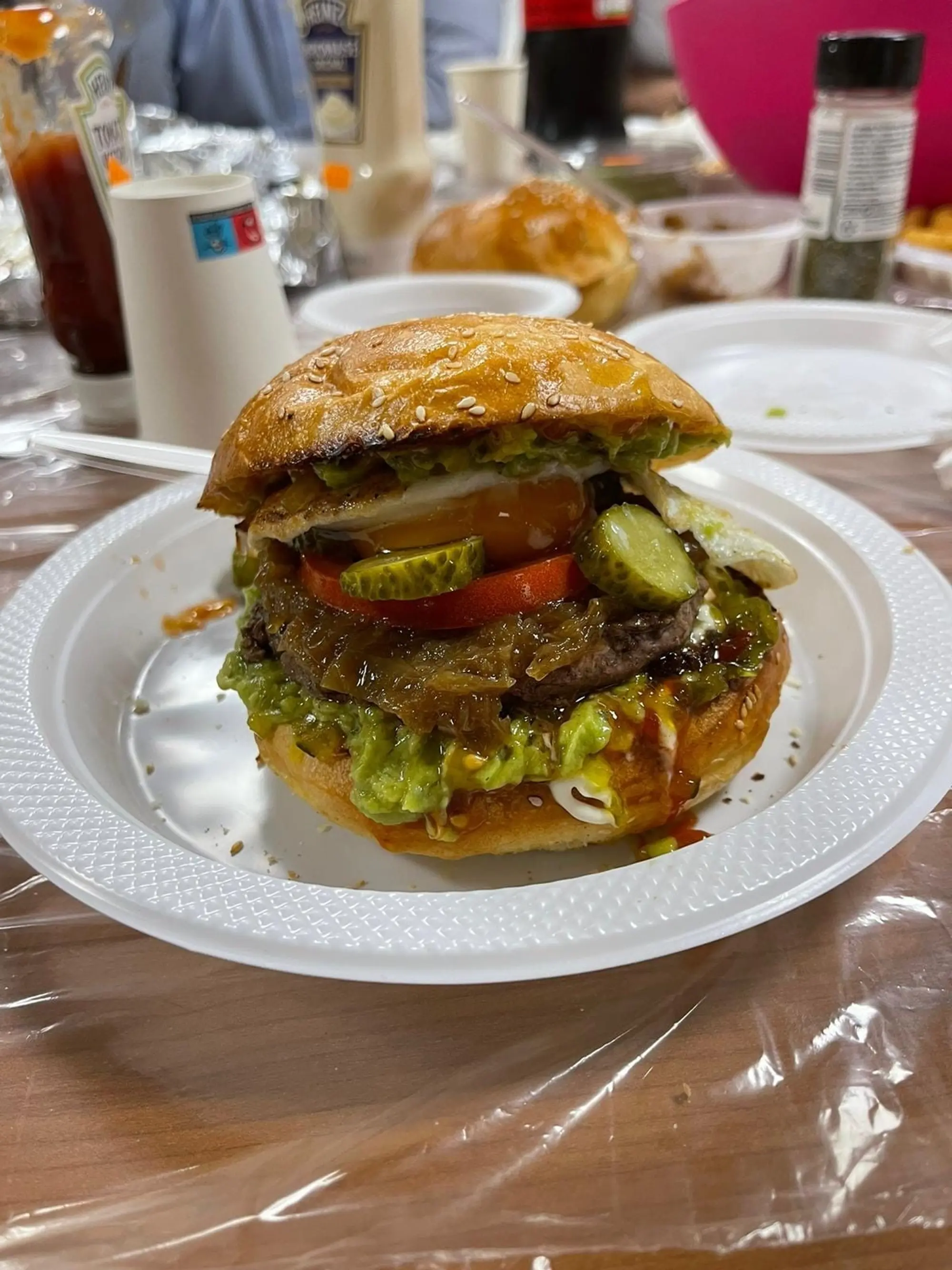 Burger avec steak, salade, tomate et œuf, servi à l’assiette