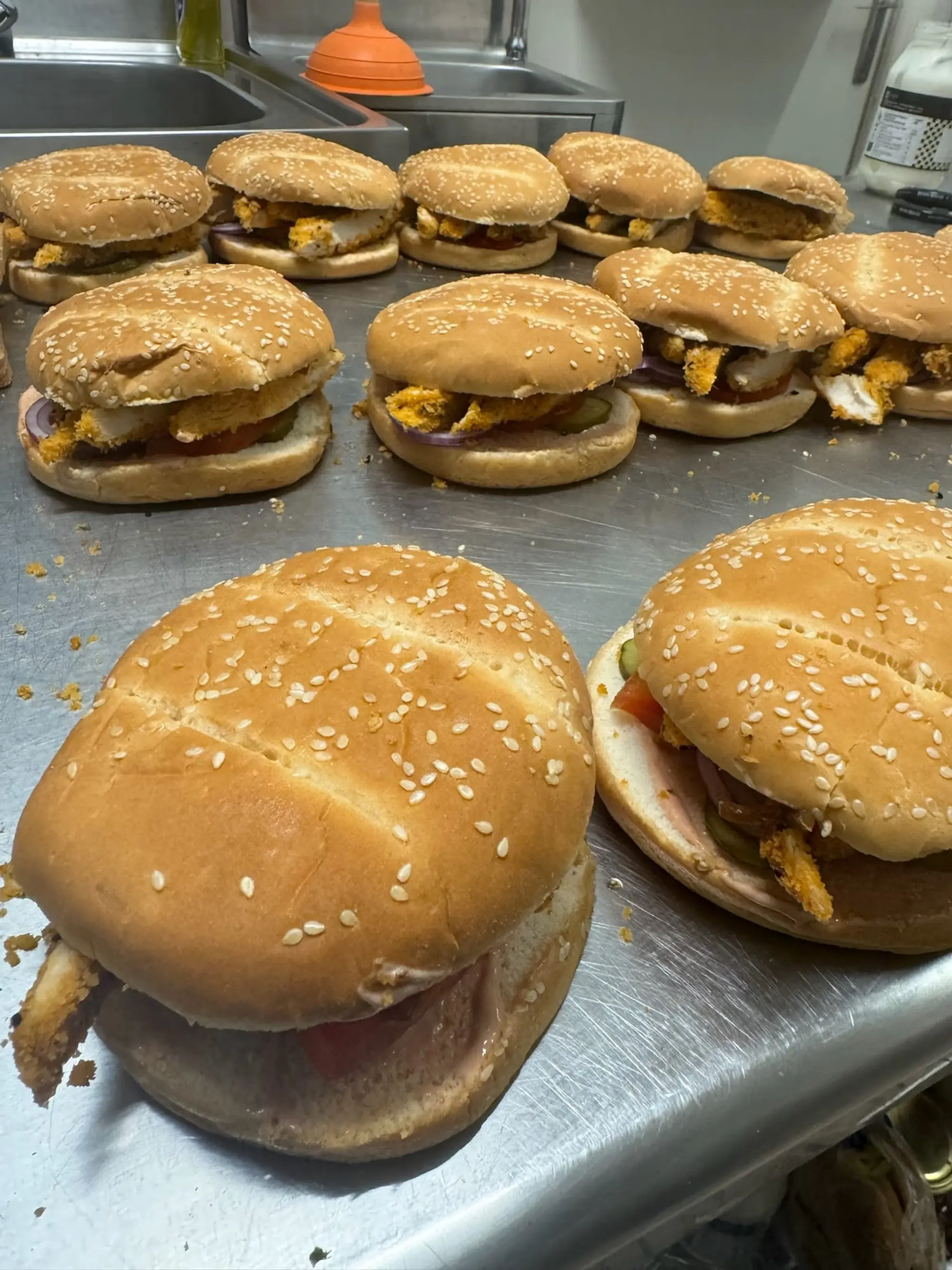 Rangées de burgers dans des pains briochés au sésame, prêts à servir