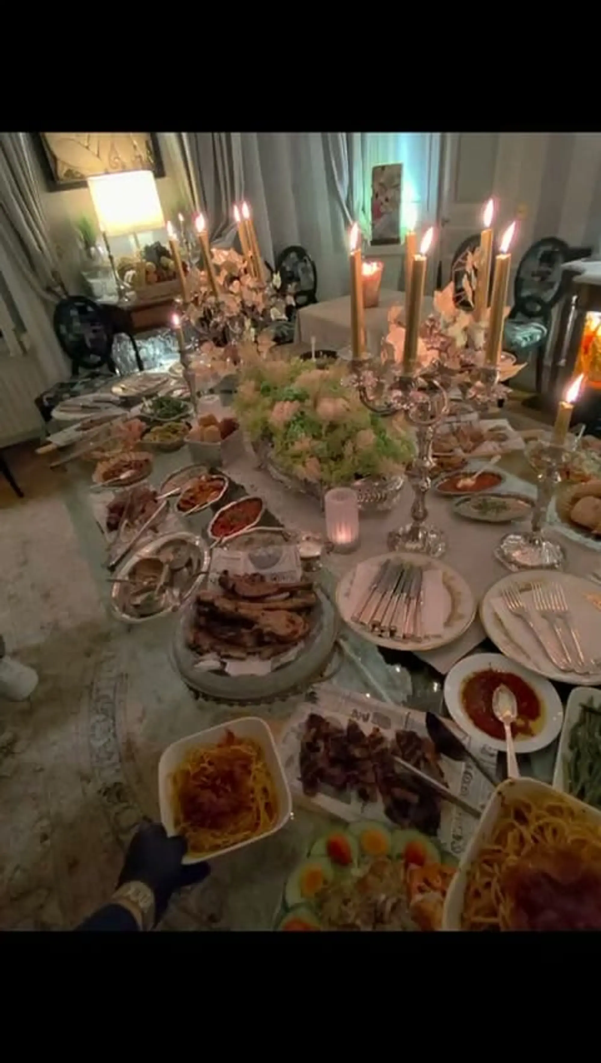 Grande table dressée avec candélabres et plats à partager dans un salon haussmannien