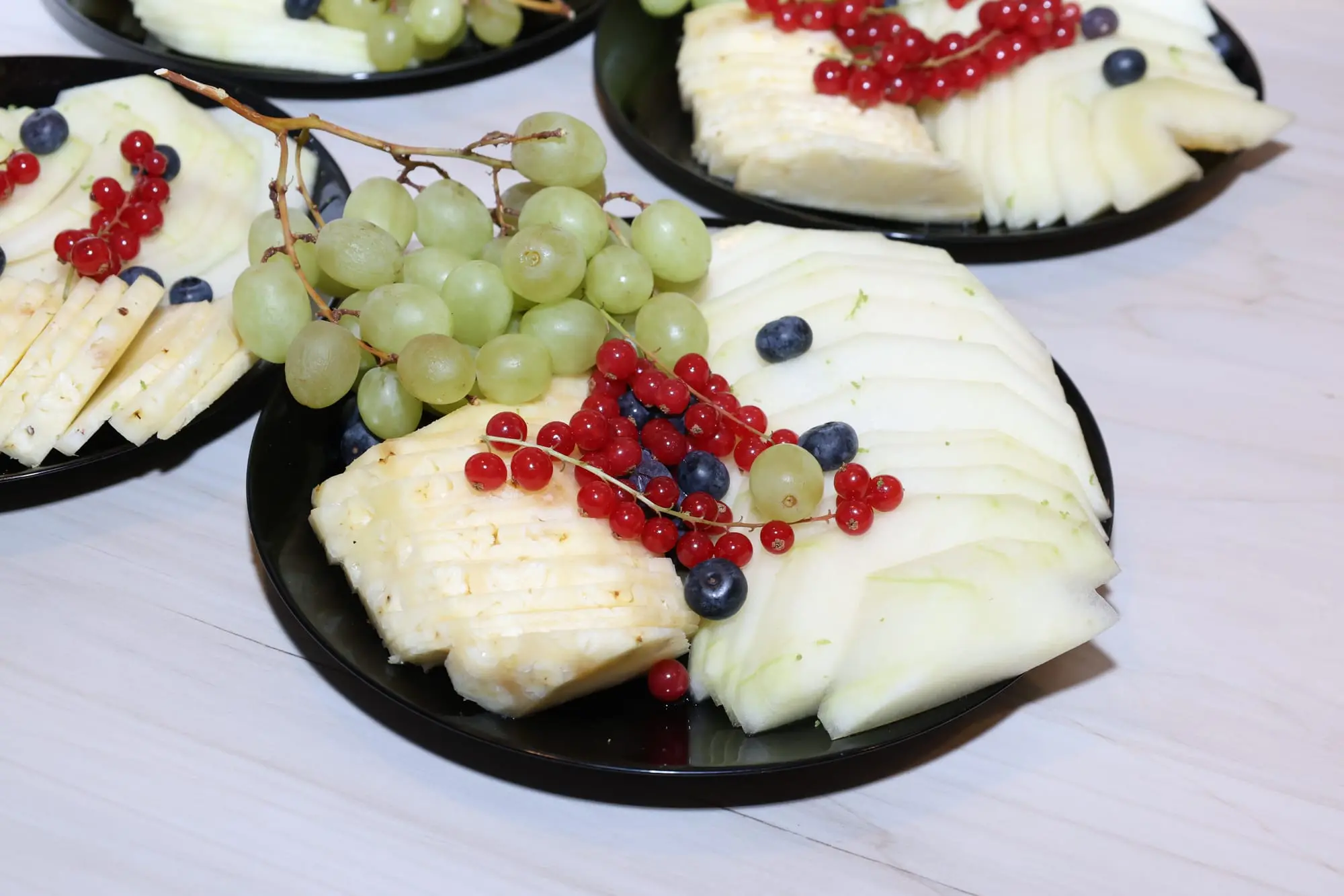 Assiettes individuelles de fromages, raisin et groseilles