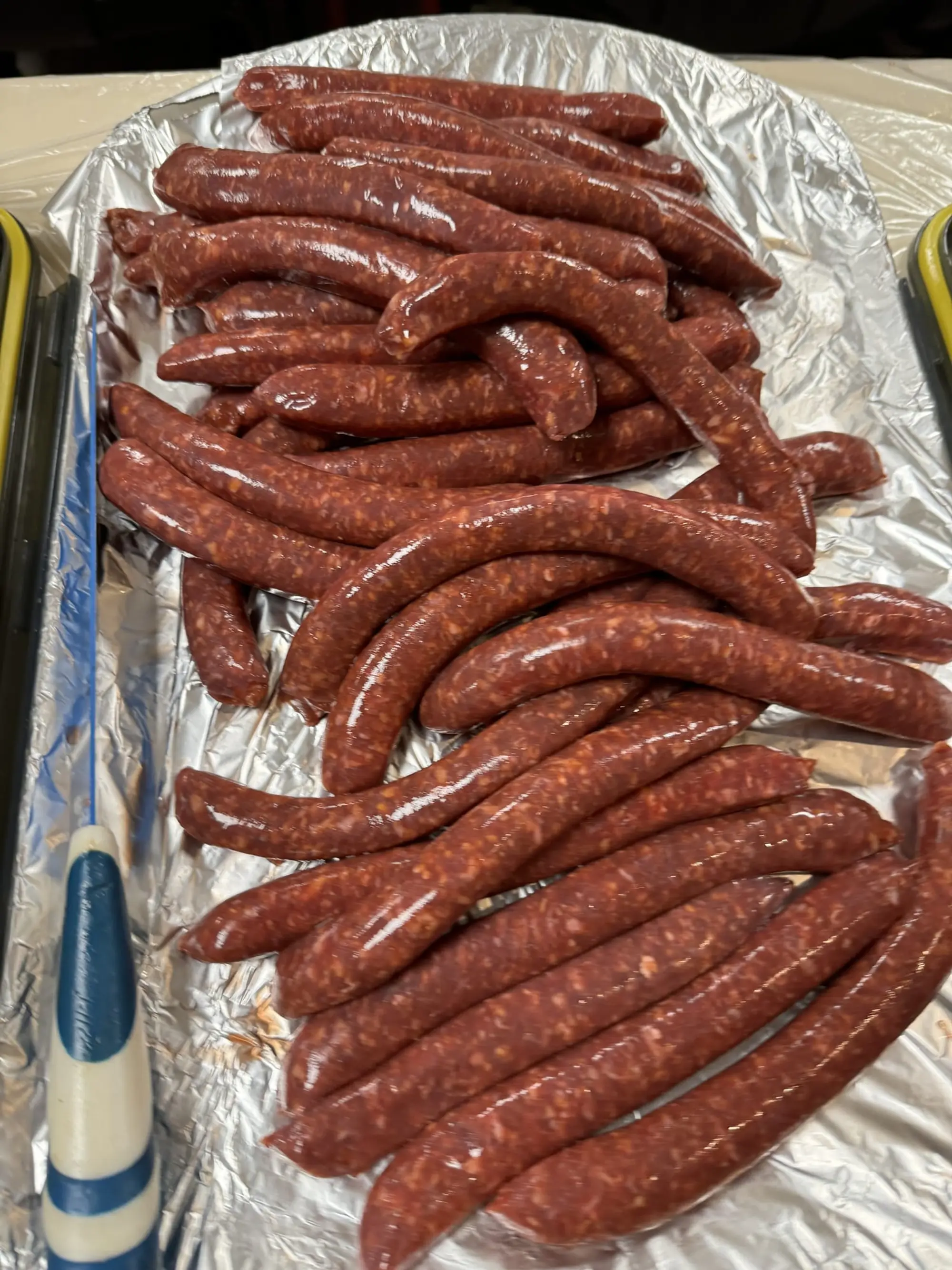Merguez alignées sur un plateau en aluminium