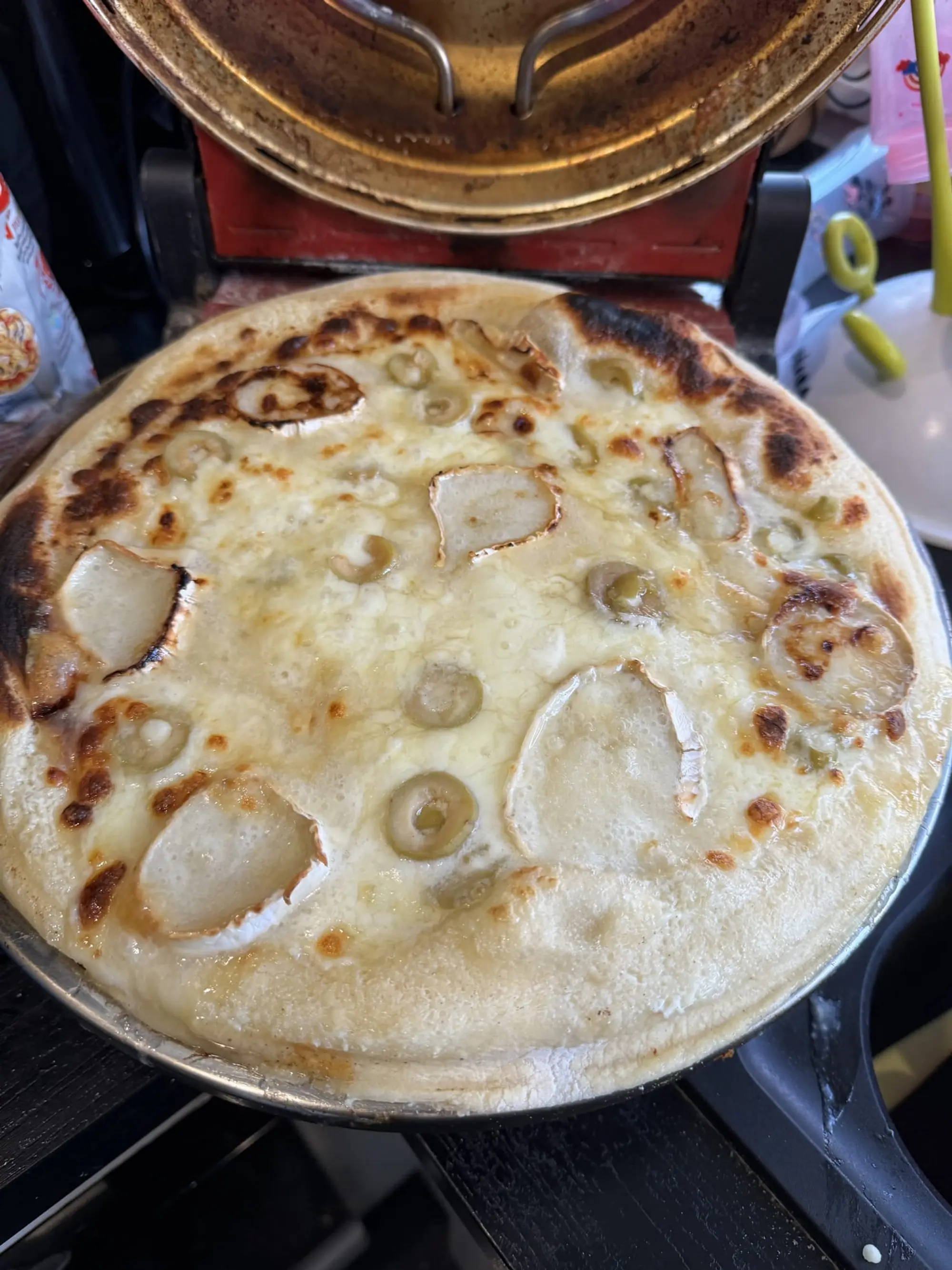 Pizza blanche au fromage sur une plaque, dans un four à pizza