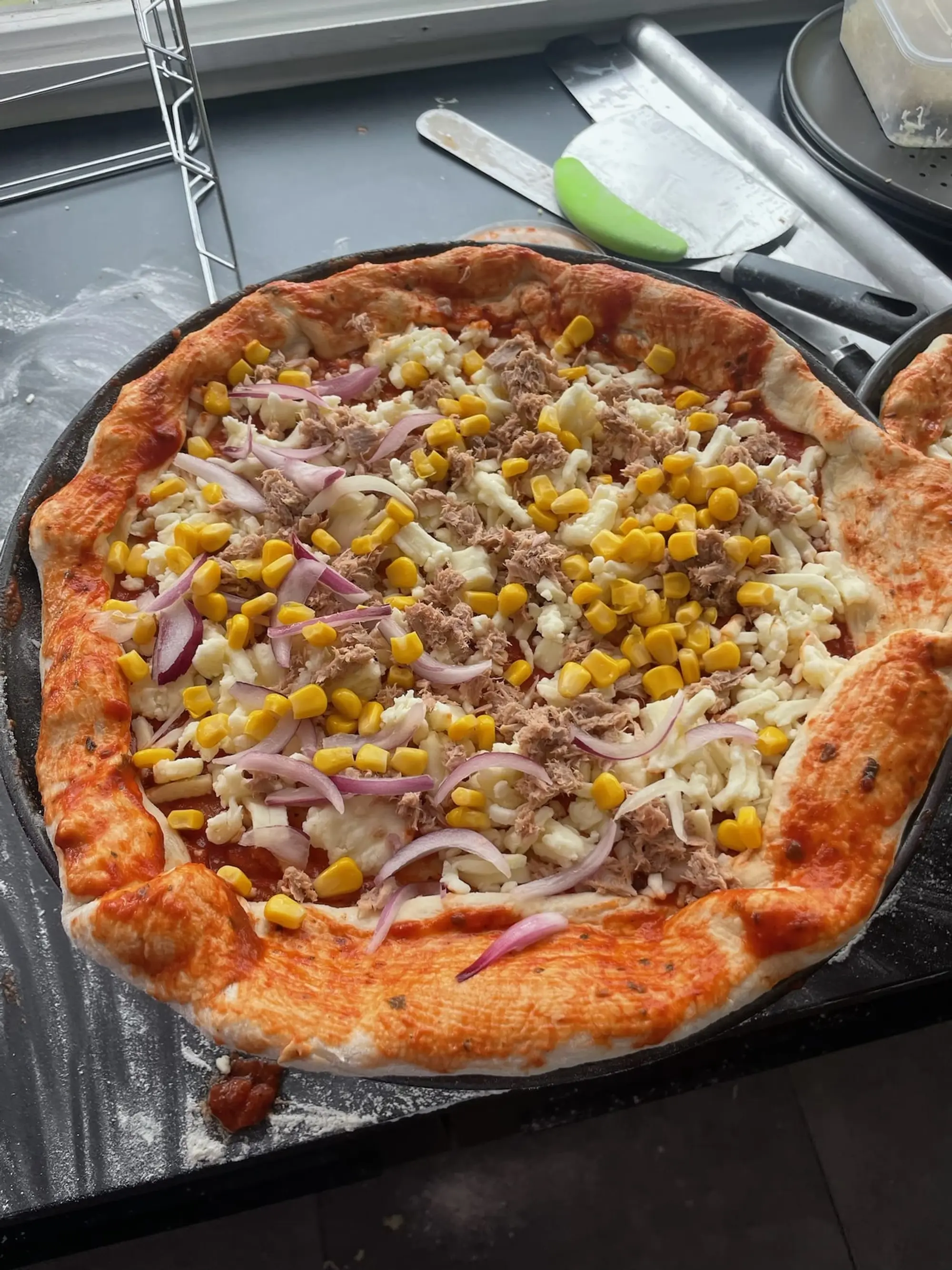Pizza garnie de thon, maïs et fromage
