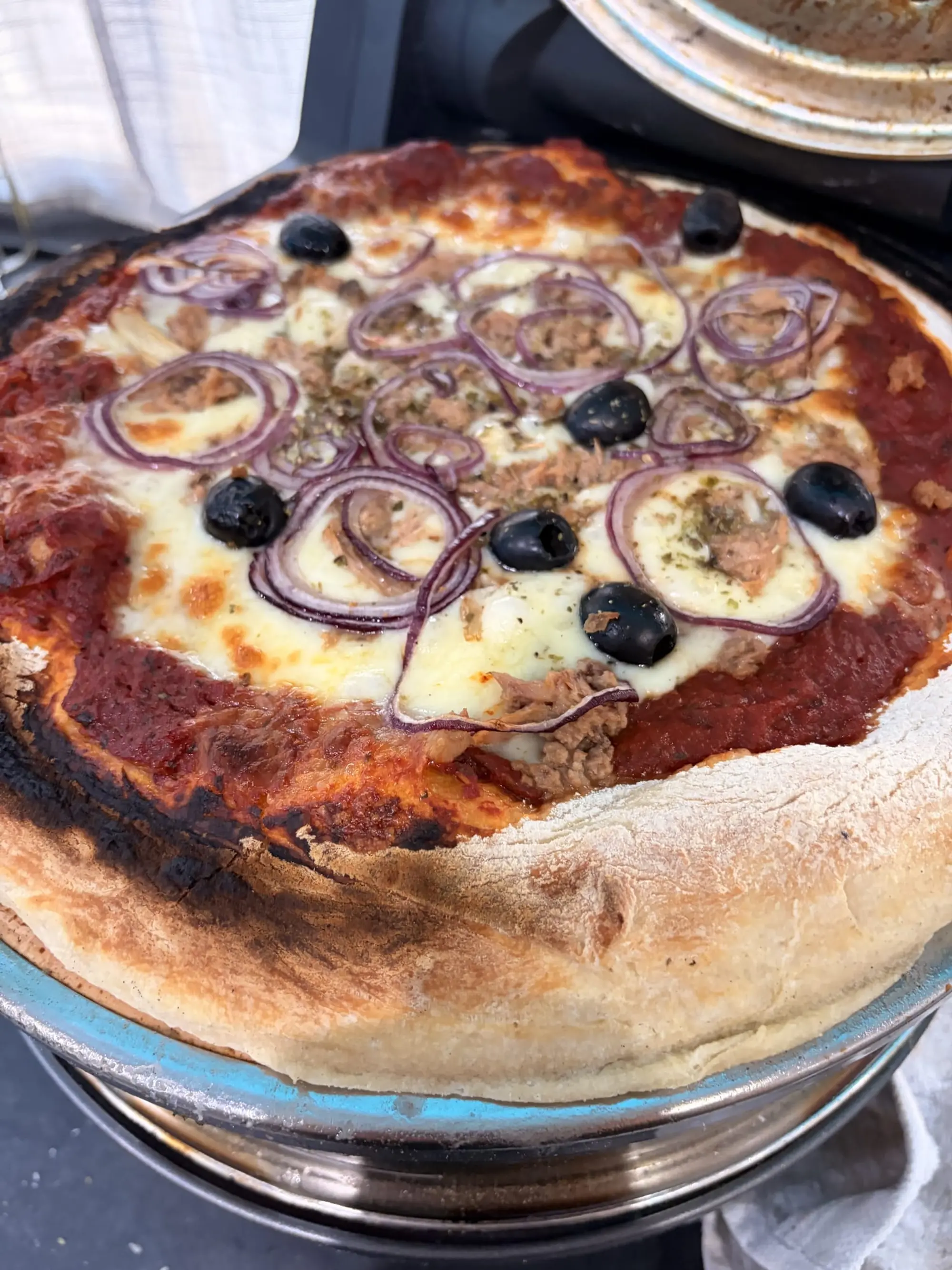 Pizza garnie d’olives noires et d’oignons rouges