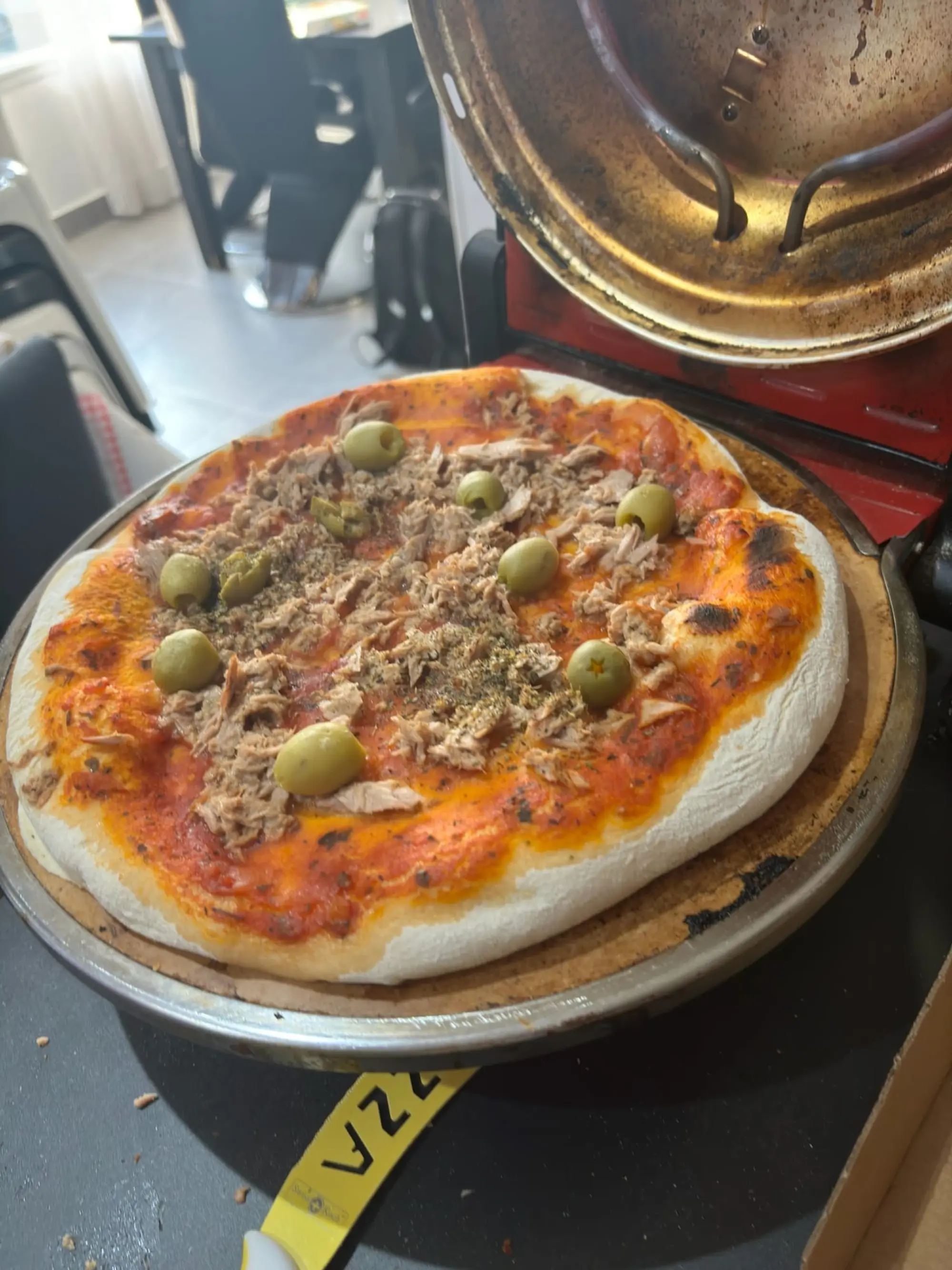 Pizza au thon et aux olives vertes sur une plaque