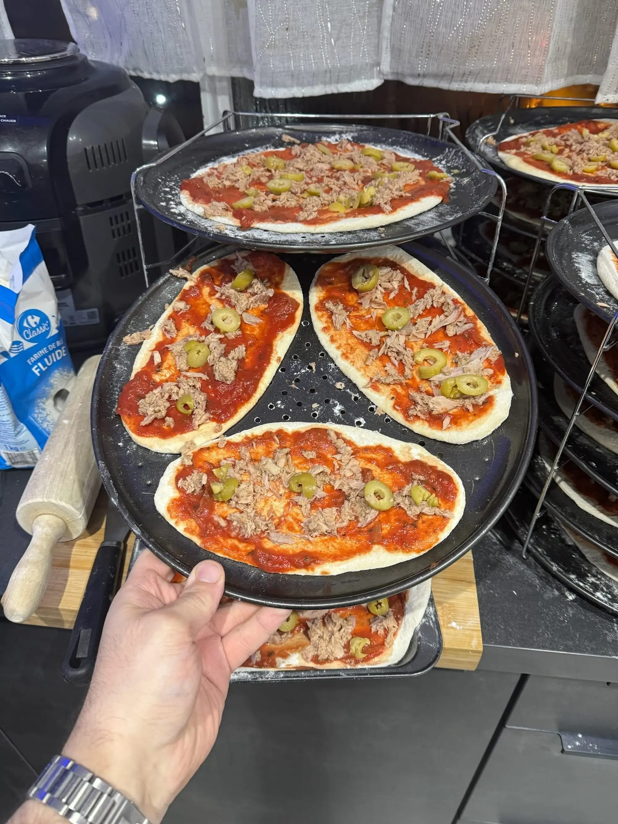 Support à plusieurs étages de pizzas individuelles garnies, tenu à la main