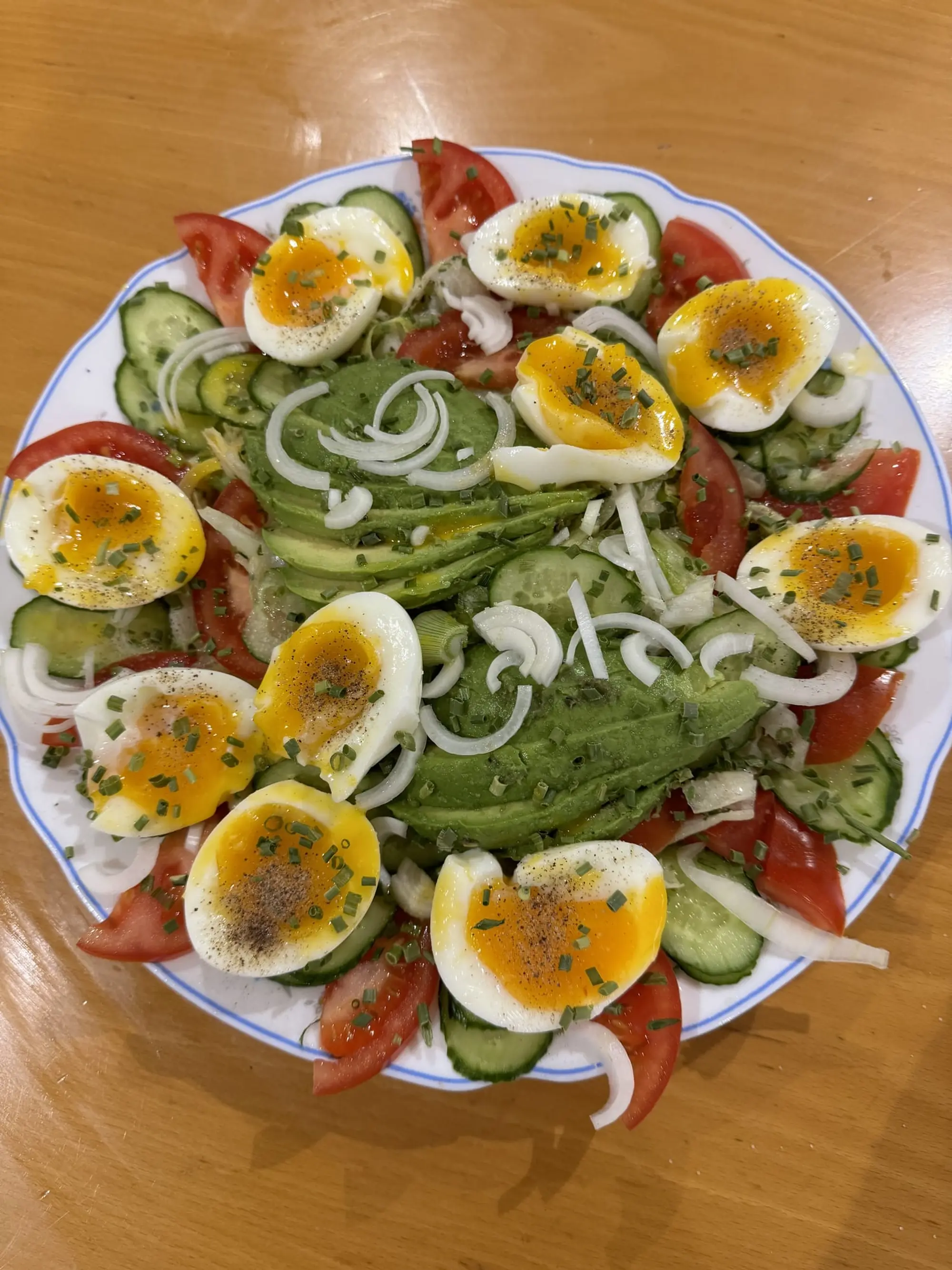 Salade dressée en couronne avec avocat, œufs durs et oignons