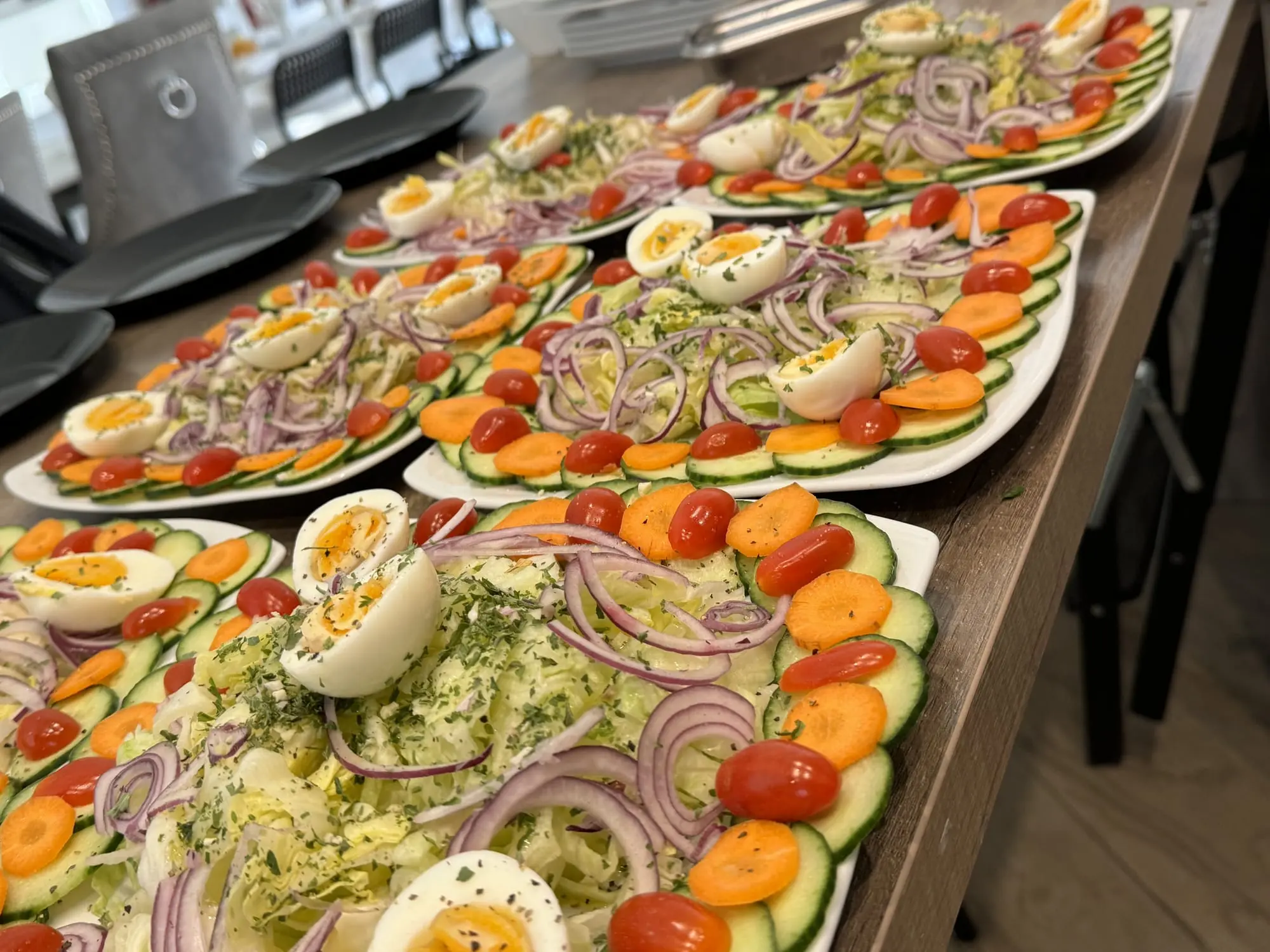 Plats de salades composées dressés sur une table en bois